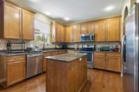 Very nice kitchen with granite countertops and tile backsplash; SS appliances; Recessed lighting and arched walkway into hallway.