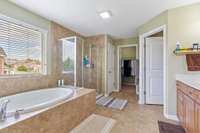 Primary Bath has tile flooring with tile shower and soaking tub; double vanities and large walk in closet with surprise closet within the closet.