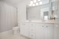 Full bathroom #2 with double sinks, tile floor, full tub and fresh paint.