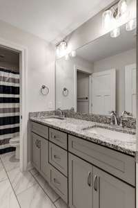 Upstairs full bath with double vanity and granite countertops