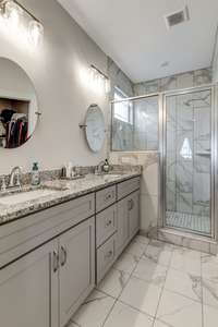 Primary bath with tile floors, granite countertops, tall double vanity