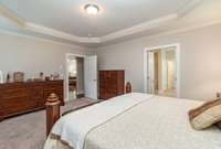 Primary bedroom flows seamlessly into grand, primary bath with walk-in shower and large soaking tub.