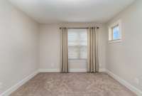 Loft area at top of stairs has plenty of natural lighting, with standard blinds to help set the mood.