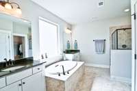 The spacious primary bath includes double vanities, a soaking tub & separate walk-in tiled shower.