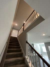 staircase leading upstairs with white wooden spindles