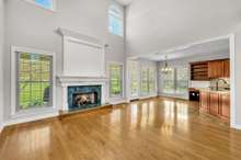 Spacious light filled living room with high ceiling.  Look at that gorgeous mantel.