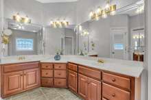 The primary bathroom features custom cherry cabinets with an oversized double vanity.