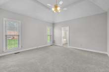 Spacious primary bedroom on main floor with tray ceiling and ensuite.