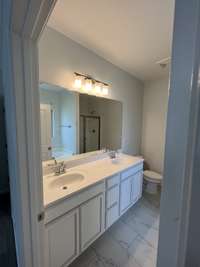 the primary bathroom with double sinks, soaking tub, shower