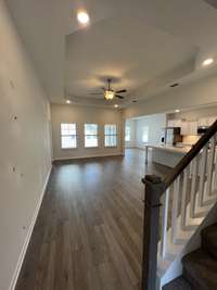 *COLORS SELECTIONS MAY VARY*  View is from the foyer looking into the great room. kitchen & dining room. This plan offers a spacious open concept. Great Room with a trey ceiling, ceiling fan, led lights in each corner of the tray. 2" window blinds