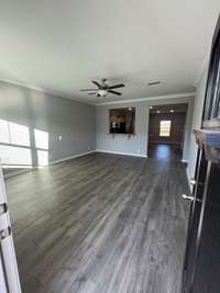 The following photos are NOT the actual home. *STOCK PHOTOS  great room with laminate flooring, blinds, craftsman door