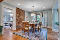 Exposed brick wall in dining area off kitchen is just one of the many charming parts of this home.