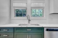 The white upper cabinets with the lower green cabinets are such a nice combination of colors.