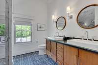 Stylish and modern upstairs bath offers dual shower heads, soapstone countertops, double vanity spectacular tile floors and shower and a vaulted ceiling.