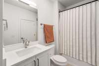 This full bathroom has a shower tub combo and its own washer and dryer hookups.