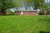 The rear of the home shows the level back yard from the back fence.