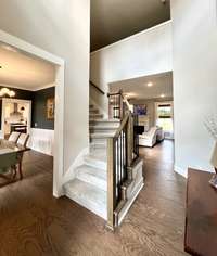 2 story high Foyer looking into Formal Dining Rm, Living Rm, staircase going up to Bonus Rm and Secondary bedrooms