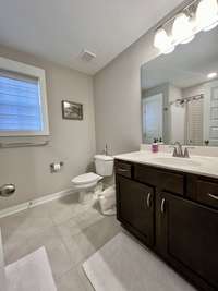 Guest bathroom has tile floor combo tub/shower