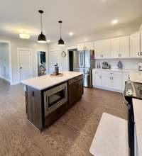 View fo kitchen from the corner looking into breakfast room, dining room, door opening to the right is to the half bath & laundry room