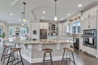 Granite countertops set the tone in the kitchen and every bathroom, replicating an aesthetic symmetry in the home’s design detail. The wraparound bar frames the space, while French-style cabinets provide plenty of storage.