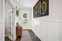 Large foyer with 10ft ceilings and wainscoting to enhance decor and protect  walls