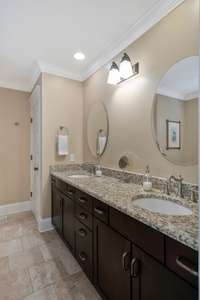 Primary bath with tile floors, granite countertops on double vanity.  Private water closet in this bath.