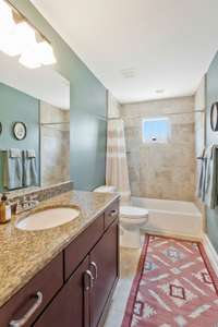 Upstairs bathroom services both bedrooms with tile floors, granite counters and tile tub surround.  Love the natural light that streams through the window high in the shower surround.