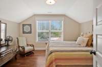 Guest room 2 with hardwood floors and walk in closet overlooking the pristine back yard.