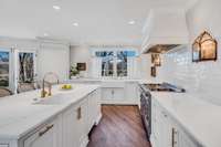 Kitchen featuring Lincoln marble tops, handmaid Spanish tile, built in refrigerator, two sinks, two dishwashers, La Cornue Le Chateau 120.