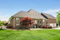 Exquisite landscaping and a sidewalk leading to the back patio and screened porch.