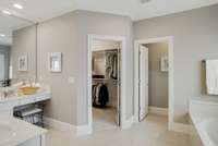 Large walk in closet with custom closet shelving and drawers.  Private water closet.