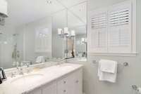 Primary bathroom with double vanity sinks and marble tops.