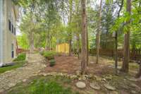 Restful backyard with trees and pebble walkways.