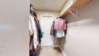 Primary walk-in closet with access to the laundry room