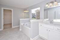 Separated vanities in the primary bathroom.  Photo not of actual home.