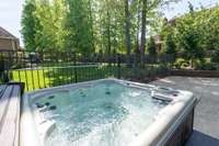 The backyard features a luxurious 5-person hot tub, perfect for relaxation and rejuvenation.