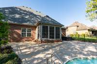 The three-seasons room at the back of the house offers dual access to the backyard, leading directly to the pool and hot tub area.