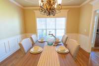 The formal dining room showcases exquisite crown molding and trim, adding a touch of sophistication. With ample space, it accommodates a large dining table, perfect for hosting elegant gatherings. A beautiful window fills the room with natural light.