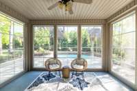 The three-seasons room at the back of the house offers dual access to the backyard, leading directly to the pool and hot tub area. Inside, it provides a picturesque view of the pool and hot tub, creating a serene and relaxing atmosphere.