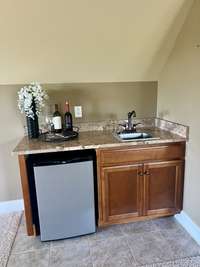 Enjoy the convenience of a wet bar complete with a refrigerator, perfect for hosting gatherings and keeping refreshments chilled. This stylish addition adds a touch of luxury to any entertainment space, making it easy to entertain with ease.