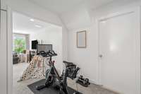 Exercise space is perfectly sized for your Peloton. Behind the door is a large walk-in storage area