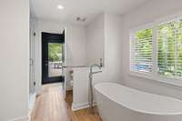 Sumptuous primary bathroom: soaking tub, walk-in shower, pool view. Indulge in luxury.