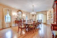 Grand dining room with two built in corner cabinets and hardwood flooring.