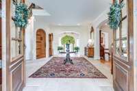 Grand entrance space with gorgeous wood doors, stone floors, and 10 foot ceilings