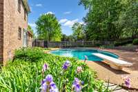 Pool is surrounded by a large aggregate deck  and  attractively landscaped areas.