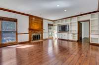 The family room will be a center for hanging out . Wood burning fireplace has gas starter,  with an easy clean floor access for cleaning ashes. Built in cabinets and shelves has area for tv.