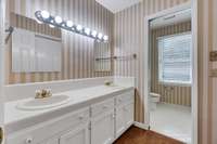 Upstairs hall bath has double vanity with  separate commode and tub/shower room