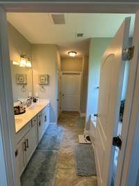 Primary suite bathroom. With seperate tub and shower. Connects to primary walk-in closet. Closet also opens up to laundry room.