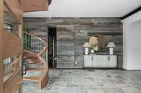 The front door opens to a foyer with a spiral stair to reach a sitting area with wet bar and access to the sky bridge and library.