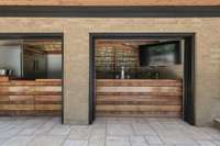 Garage style doors open to reveal this indoor/outdoor bar.